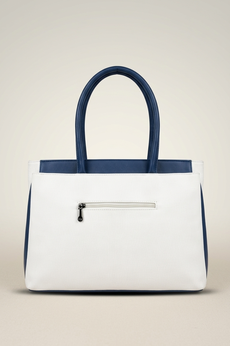 White handbag with navy accents on a beige background