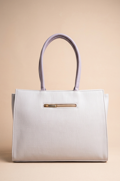 White handbag with a gold zipper on a beige background