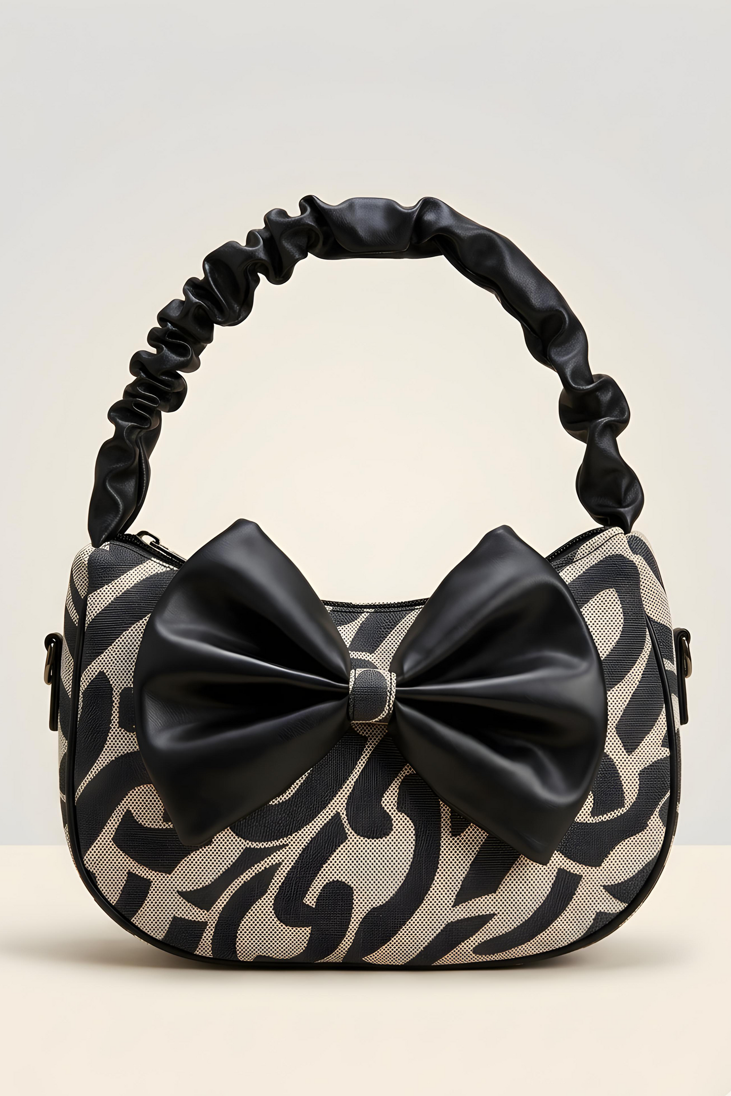 Handbag with black and beige pattern and a large bow on a light gray background