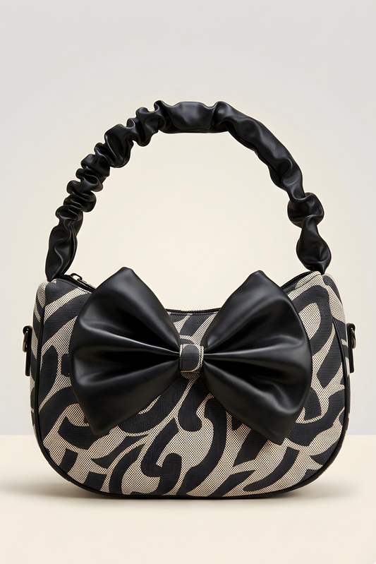 Handbag with black and beige pattern and a large bow on a light gray background
